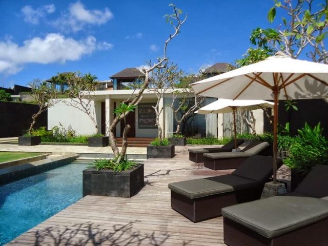 Terrace with rattan furniture and an umbrella at Villa Biu-Biu S01