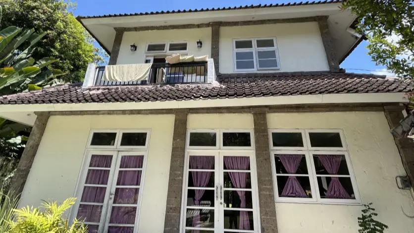 Exterior of Villa Gloria, a two-storey house with a balcony in Seminyak