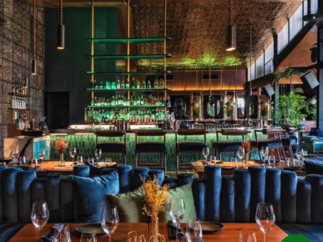 Dining room with tables, blue chairs, and plants at Jade restaurant