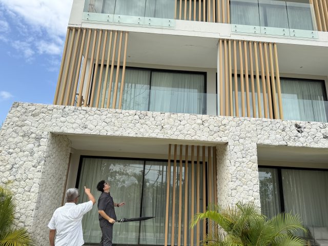 Apartment building exterior with stone and timber cladding at Karma Kandara