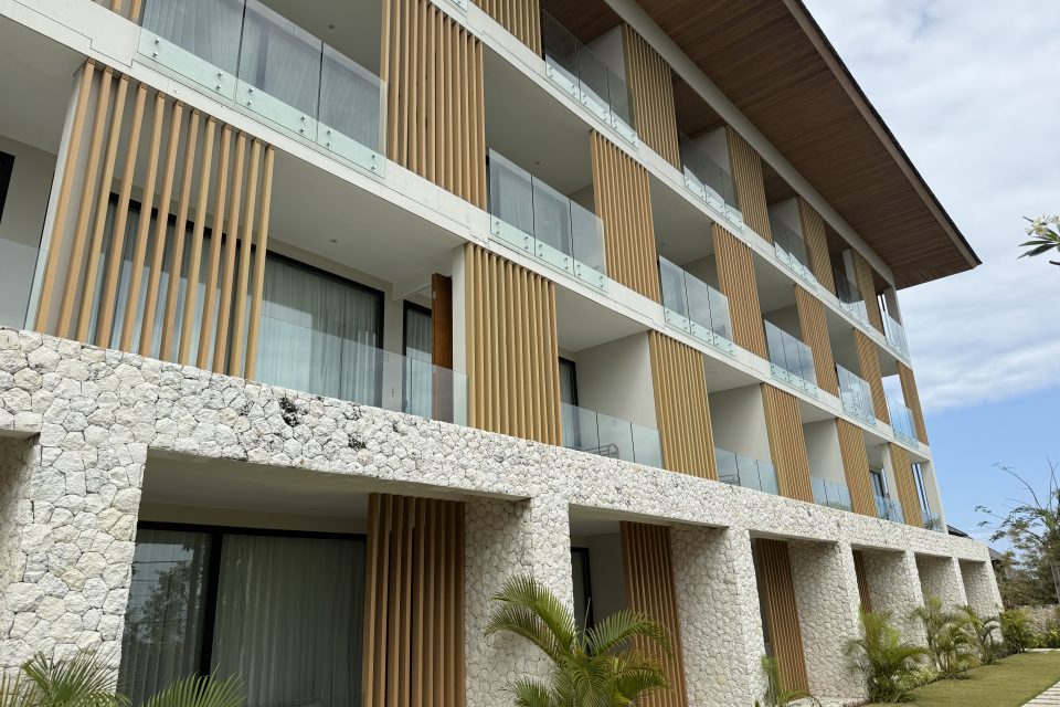 Exterior of the apartment building with a stone and timber façade at Karma Kandara